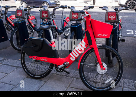 Uber Jump red e-bike sinistra accanto a cicli di Santander, London, England, Regno Unito Foto Stock