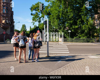 Un gruppo di ragazze adolescenti in attesa di cross street a crosswalk, Strasburgo, Alsazia, Francia, Europa Foto Stock