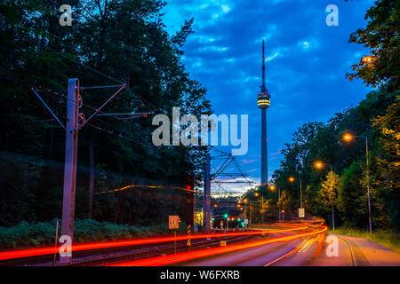 In Germania, la torre della televisione di Stoccarda città chiamata fernsehturm nella magica atmosfera del crepuscolo dopo il tramonto con la strada piena di traffico Foto Stock