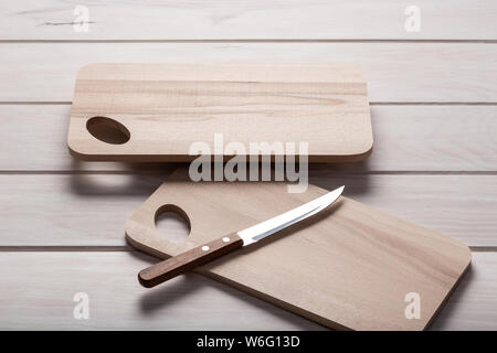 Svuotare la scheda di taglio su un tavolo di legno con il coltello. Alimentare il concetto di sfondo. Spazio di copia Foto Stock