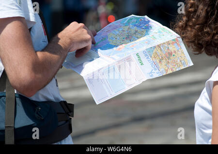 L'Italia, Lombardia, Milano, Coppia Giovane navigando in una mappa Foto Stock