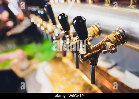 Molti rubinetti di birra nel bar di birra. Foto Stock