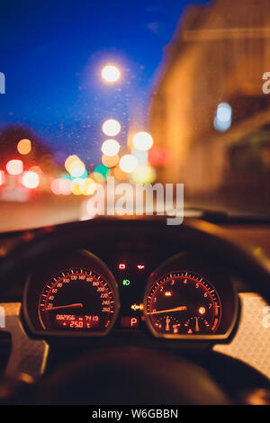 Il tachimetro rigature ad alta velocità in un movimento veloce. Auto sportiva gli strumenti del cruscotto illuminato di notte. Il contagiri. Veicolo moderno cluster. Foto Stock