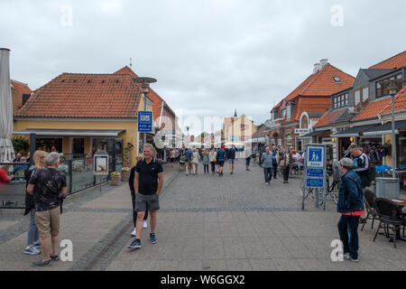 I visitatori di pittoresca Skagen a piedi lungo la strada principale con i suoi negozi cafe bar e ristoranti, nel tardo pomeriggio dopo il tramonto Foto Stock