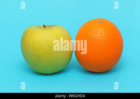 Apple e arancia fresca frutta organica su sfondo blu Foto Stock