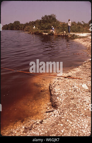 La pesca in canale fuori la Highway 11, sulla riva sudorientale del lago Pontchartrain. Inquinamento ha girato l'acqua marrone Foto Stock