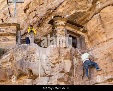 Uomo che sale su una corda per raggiungere il monastero di Debre Damo; Tigray Regione, Etiopia Foto Stock