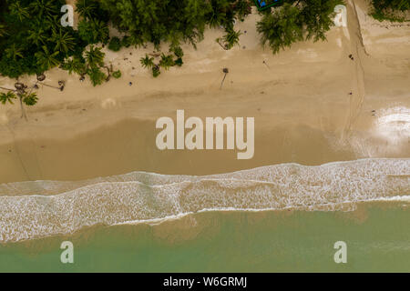 Vista aerea di onde che si infrangono su un vuoto, sabbiosa spiaggia tropicale Foto Stock