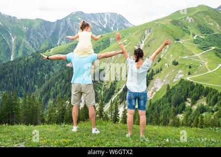 Vista posteriore della famiglia felice Guardando vista panoramica sulla montagna Foto Stock