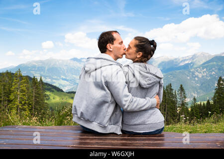 Giovane seduto su un banco di lavoro gode di vista panoramica sulla montagna Foto Stock