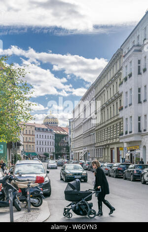 Berlino, Germania - 26 settembre 2018: vista verticale di una madre che attraversa la strada con un passeggino vicino al Neue Synagogue, un punto di riferimento degli ebrei Foto Stock