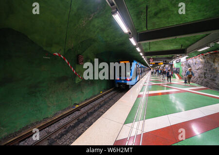 Il treno nel tunnel di Kungstradgarden stazione della metropolitana, scavate nella roccia e dipinte con colori vibranti, Stoccolma, Svezia Foto Stock