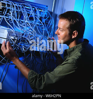 Lavorando in un computer in sala server Foto Stock