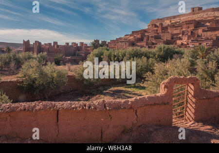 Ouarzazate, Marocco, Africa - 15 Gennaio 2014: vista del centro storico della città di Ouarzazate in background, in primo piano un muro di adobe con un piccolo Foto Stock