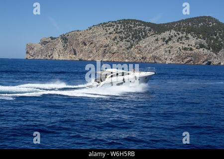 MALLORCA, Spagna - 23 giugno 2019: imbarcazione a motore con la donna velocizzando rendendo le onde spumeggianti in una giornata di sole a giugno 23, 2019 a Mallorca, Spagna. Foto Stock