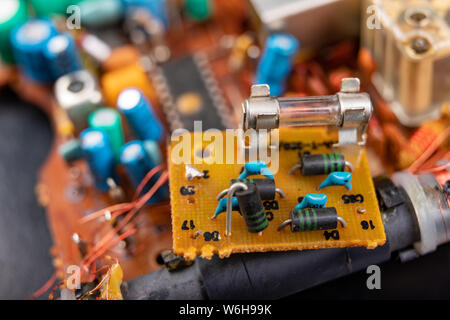 Electronics dai vecchi dispositivi elettronici. Parti di ricambio per riparare in un laboratorio di elettronica. Sfondo scuro. Foto Stock