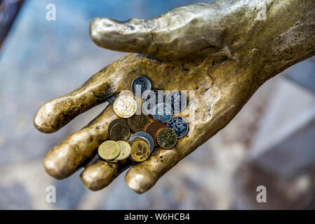 Fisherman scultura con monete in esso la mano in un porto; Opatija, Primorje-Gorski Kotar County, Croazia Foto Stock