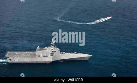 L'U.S Navy indipendenza-variante Littoral Combat Ship USS Gabrielle Giffords manovre per scoraggiare un recipiente senza equipaggio durante una piccola barca di esercizio attacco Luglio 26, 2019 nell'Oceano Pacifico orientale. Foto Stock