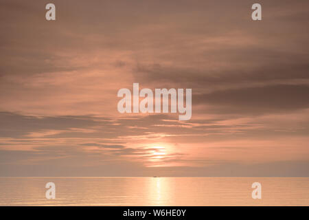 Barca dei pescatori contro silhouette orange sunrise sul Lago Malawi, il sole glitter sul lago, sud-est-africa Foto Stock