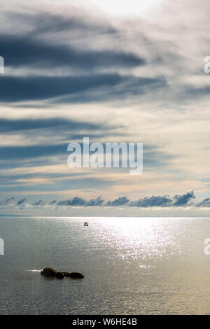 Barca dei pescatori silhouette contro Alba sul lago Malawi, il sole glitter sul lago, sud-est-africa Foto Stock