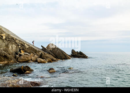 L uomo sulla scogliera a Corniglia (cinque terre) Foto Stock