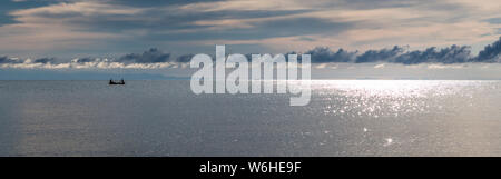 Barca dei pescatori silhouette contro Alba sul lago Malawi, il sole glitter sul lago, sud-est-africa Foto Stock