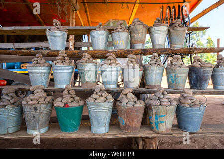 Un africano del Malawi stallo alimentari vendita di patate fresche in ferro bucket in una strada locale mercato alimentare. Lilongwe, Malawi Foto Stock