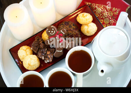 Il tè serviti su un vassoio con i cookie e le candele di Natale; Surrey, British Columbia, Canada Foto Stock