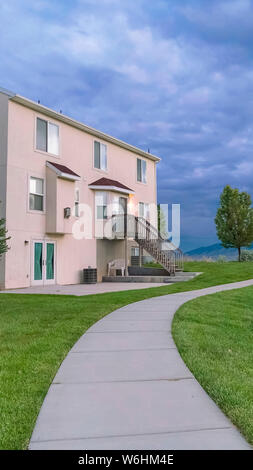 Telaio verticale paesaggio panoramico con una casa che si affaccia su uno stagno e il percorso su un campo erboso Foto Stock