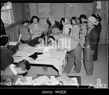 Manzanar Relocation Center, Manzanar, California. Agli sfollati di ascendenza giapponese la firma per il lavoro . . .; Portata e contenuto: tutta la didascalia per questa fotografia si legge: Manzanar Relocation Center, Manzanar, California. Agli sfollati di ascendenza giapponese la firma per lavorare a questa guerra Autorità di Relocation Center. Foto Stock