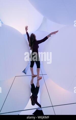 Giovane donna, grande illuminato sfere, installazione LED nel Digital Art Museum, TeamLab pianeti, Koto City, Tokyo, Giappone Foto Stock