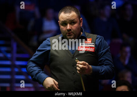 Stephen Maguire della Scozia chalks spunto come egli ritiene che un colpo a Li appendere della Cina per il loro match di primo turno durante il 2018 Ladbrokes World Grand Foto Stock