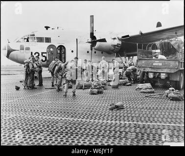 Paracadutisti del reggimento 187th combattere Team hanno messo in paracadute e Mae West ciambelle salvagente prima di salire a bordo di una truppa 483rd ala portante U.S. Air Force C-119 Flying Boxcar, in rotta verso la Corea del sud giappone; Portata e contenuto: i paracadutisti del Reggimento 187th combattere Team hanno messo in paracadute e Mae West ciambelle salvagente prima di salire a bordo di una truppa 483rd ala portante U.S. Air Force C-119 Flying Boxcar, in rotta verso la Corea del sud giappone. La lotta contro il carico Commandos e C-119s trasferito in aereo il 187th RCT personale e armi, veicoli e materiali di consumo in un funzionamento continuo della durata di due notti di un Foto Stock