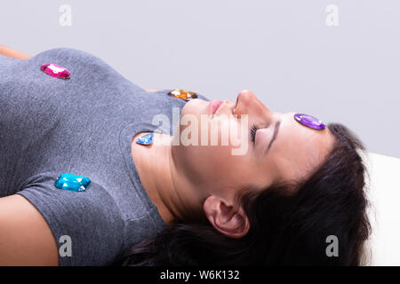 Foto di giovane donna in fase di hypnotherapy con pietre Foto Stock