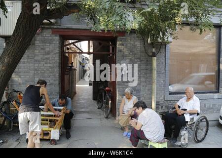 --FILE--anziani locali persone sedersi e chat in un hutong (vicolo) a Pechino in Cina, 22 giugno 2015. Il numero di persone di età compresa tra 60 o sopra aveva raggiunto 241 Foto Stock