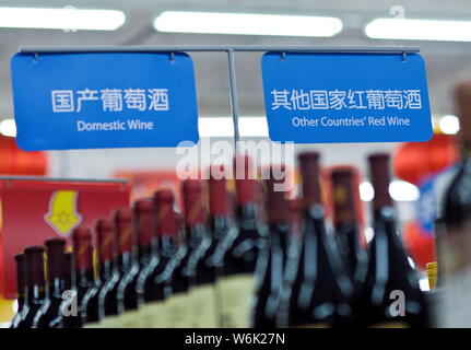 --FILE--bottiglie di vino domestico e vino importato da paesi stranieri sono in vendita in un supermercato in città di Guangzhou, a sud della Cina di Guangdong pro Foto Stock