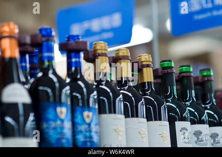 --FILE--bottiglie di vino domestico e vino importato da paesi stranieri sono in vendita in un supermercato in città di Guangzhou, a sud della Cina di Guangdong pro Foto Stock