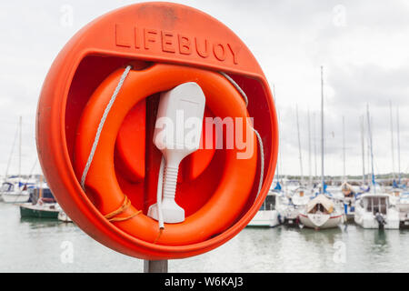 Ciambella rosso collocato sul lago costa nel porto di Almere, Paesi Bassi Foto Stock