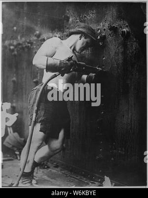 Rivettatrice a lavorare a Hog Island cantiere navale. In Pennsylvania, 1918. Kadel & Herbert., 1917 - 1919; Note Generali: Utilizzo di guerra e di conflitto numero 534 quando si ordina una riproduzione o la richiesta di informazioni su questa immagine. Foto Stock