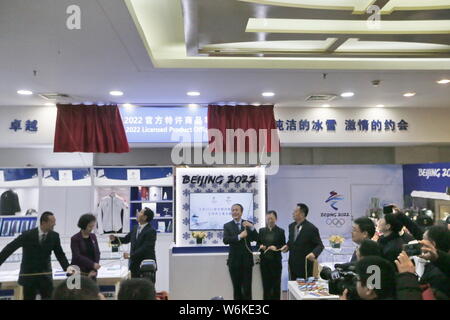 I dipendenti cinesi svela il cartello durante la cerimonia di apertura di uno del primo lotto di prodotti concessi in licenza i negozi ufficiali per la Pechino 202 Foto Stock