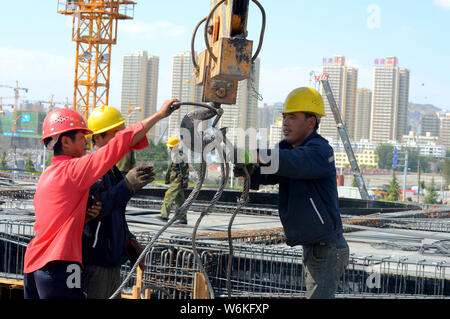 Cinese i lavoratori migranti il lavoro in un cantiere di Lanzhou la linea 1 del Metro a Lanzhou city, a nord-ovest della Cina di provincia di Gansu, 2 agosto 2016. Foto Stock