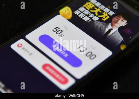 Un partecipante cinese usa il suo smartphone per rispondere alle domande del quiz livestreaming piattaforma Yingxiong Baiwan di live video streaming app Xigua Vi Foto Stock