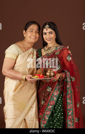 Woman with her daughter holding pooja thali Stock Photo