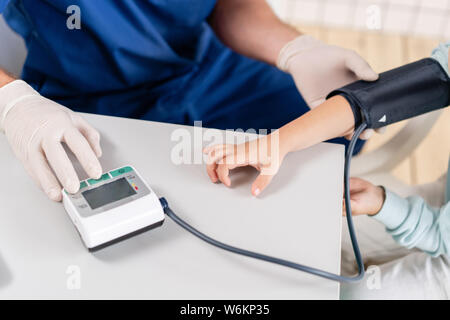 Close-up di apparecchiatura per la misurazione della pressione del sangue. Medico la misura della pressione del sangue di un ragazzino. Diagnostica, sanitario, servizio medico Foto Stock
