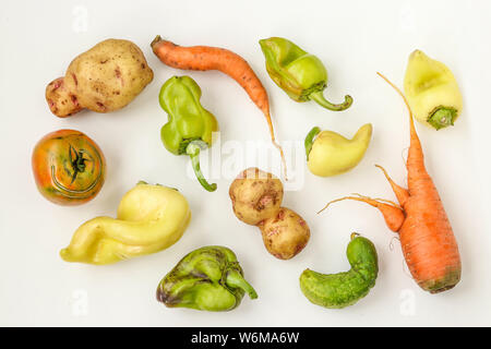 Brutto ortaggi: patate, carote, cetrioli, peperoni e pomodori su sfondo bianco, brutto concetto alimentare, la foto in orizzontale, vista dall'alto Foto Stock