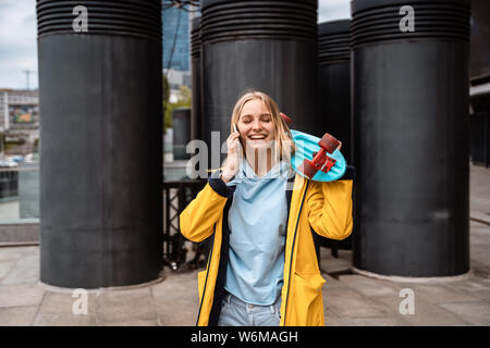 Bella ragazza chiamate dal telefono, sorridenti parlando sullo smartphone. Foto Stock