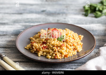 Ptitim o Birdy, Israeliano paste alimentari Cuscus con pomodori e le erbe/ Foto Stock