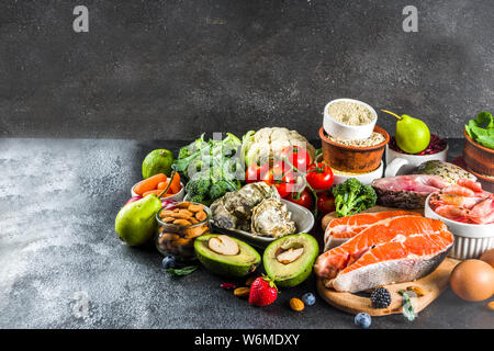 Pescetarian diet plan ingredienti, sana e bilanciata alimenti alimentari, frutta fresca e bacche, pesci e crostacei vongole, in pietra nera di calcestruzzo copia in background Foto Stock