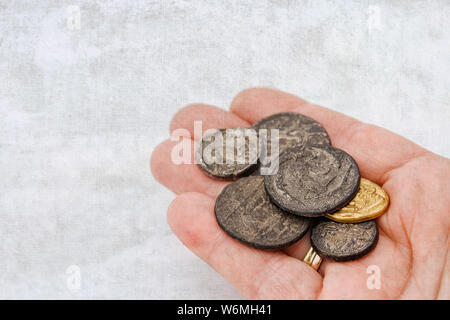 Mano con una raccolta di vecchie monete romane Foto Stock