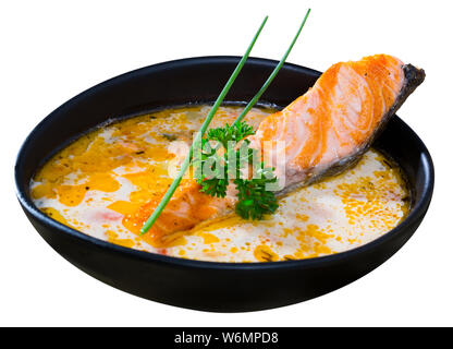 Tradizionale norvegese zuppa cremosa con salmone servito in tazza nera. Isolato su sfondo bianco Foto Stock